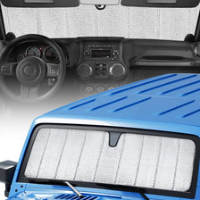 A blue Jeep Wrangler windshield with a white custom-fit sunshade installed.
