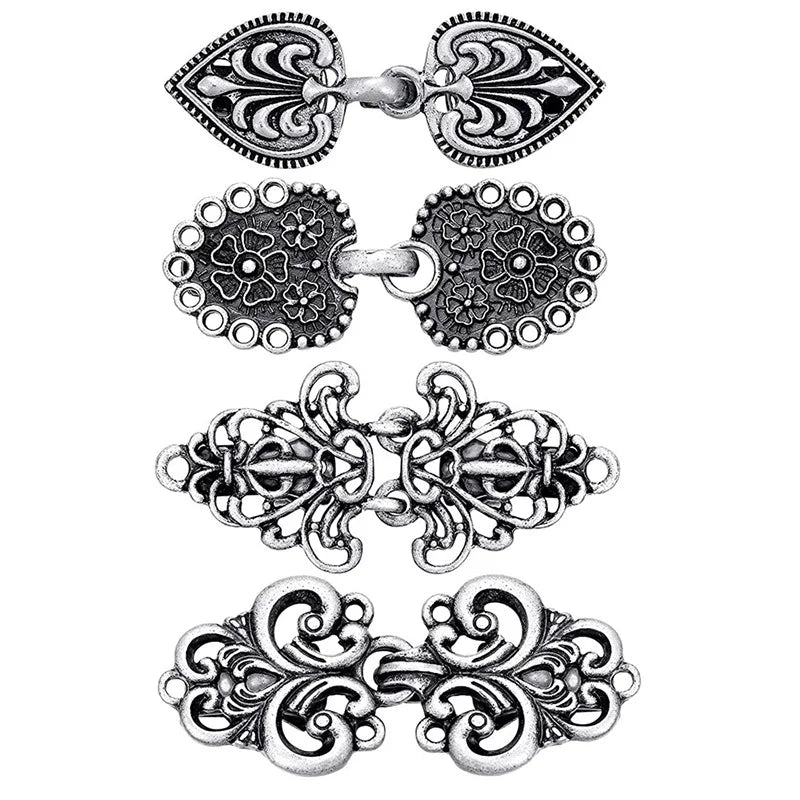 A set of vintage rotating sweater clips for cardigans and shawls, featuring ornate silver-toned metal designs.