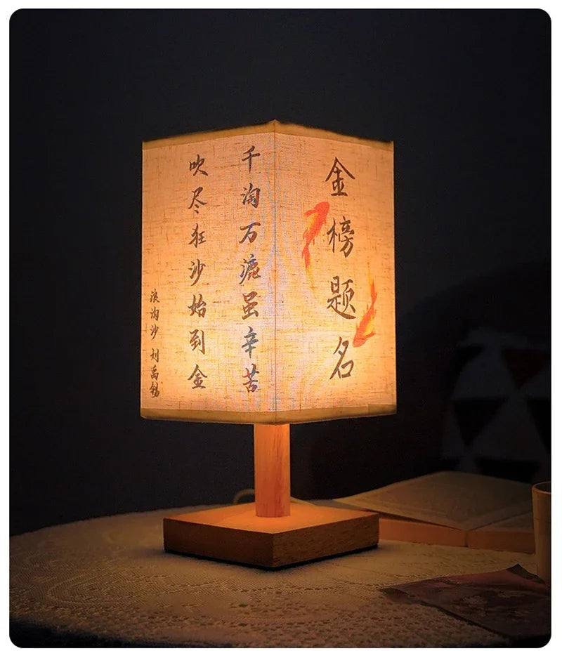 A traditional Chinese style table lamp with a light-colored linen shade displaying vertical calligraphy on a dark background.