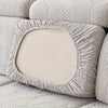 A light beige stretch jacquard sofa cover featuring a leaf pattern and a decorative oval insert.