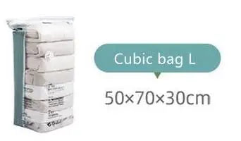 Pile d'articles en tissu blancs dans un sac cubique étiqueté Cubic bag L avec des dimensions de 50x70x30cm