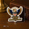 A vintage American eagle lapel pin featuring the USA flag design and the text 250 Anniversary, displayed on a wooden surface.