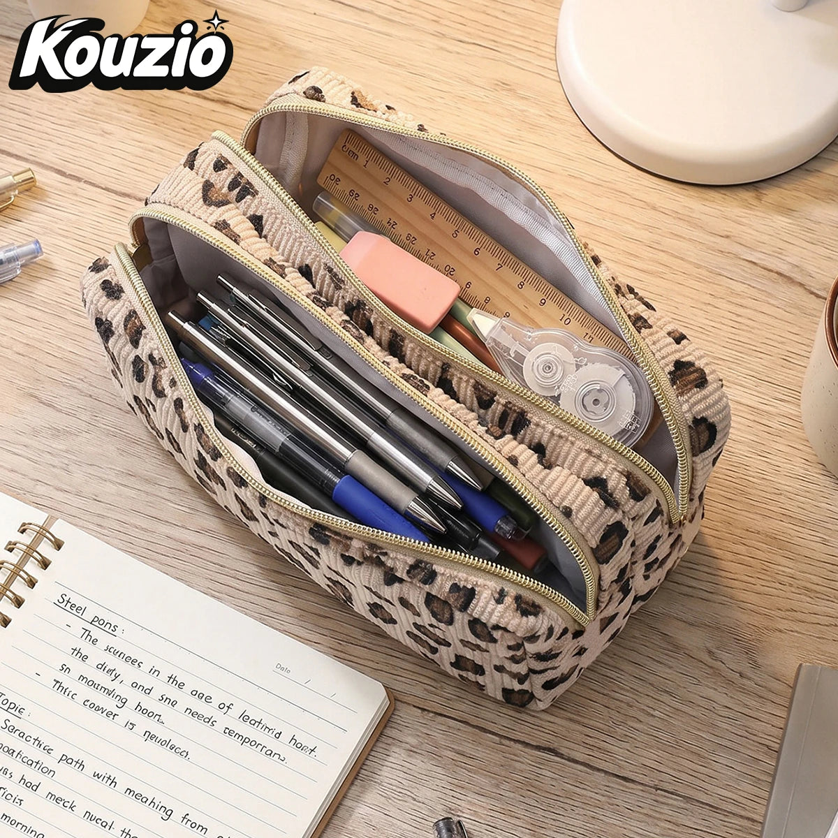 A leopard print double-zip pencil case is shown open, revealing pens and pencils inside on a wooden surface.
