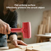 A hand is using a red rubber mallet to strike a wooden surface for tile work or DIY projects.