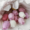 A collection of pink and white silicone tulip molds for candle and soap making displayed in light paper.