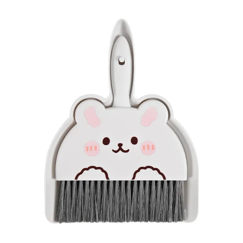 A white cartoon broom and dustpan set with a cute animal face design.