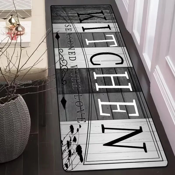 A long rectangular mat with the text 'KITCHEN' in various fonts and designs on a dark background.