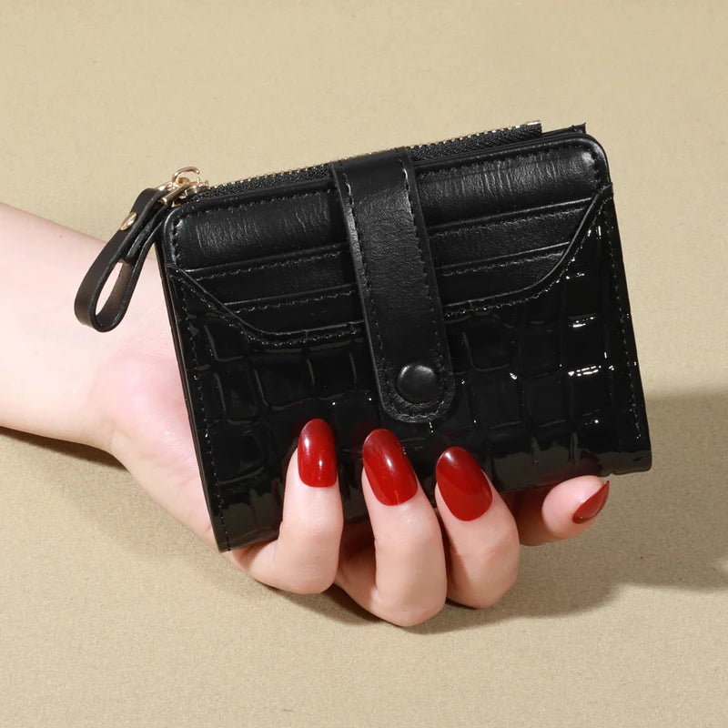 A hand holds a black PU leather wallet with a flap and zipper on a beige background.