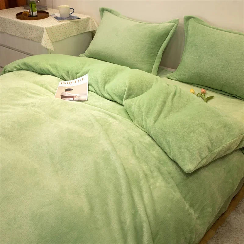 A light green flannel duvet cover with matching pillows and a small book on the bed.