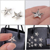 Silbersterneinsätze für Kleidung und Accessoires auf einer schwarzen Handtasche.