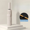 A white double dragon bone folding umbrella standing on a white surface.