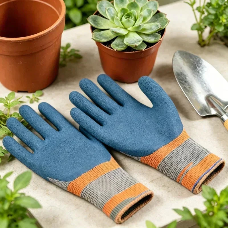A pair of blue gardening gloves with orange grips resting on a light surface next to potted plants.