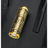 A close-up of a gold-colored electric razor with a Buddha face design resting on a black surface.