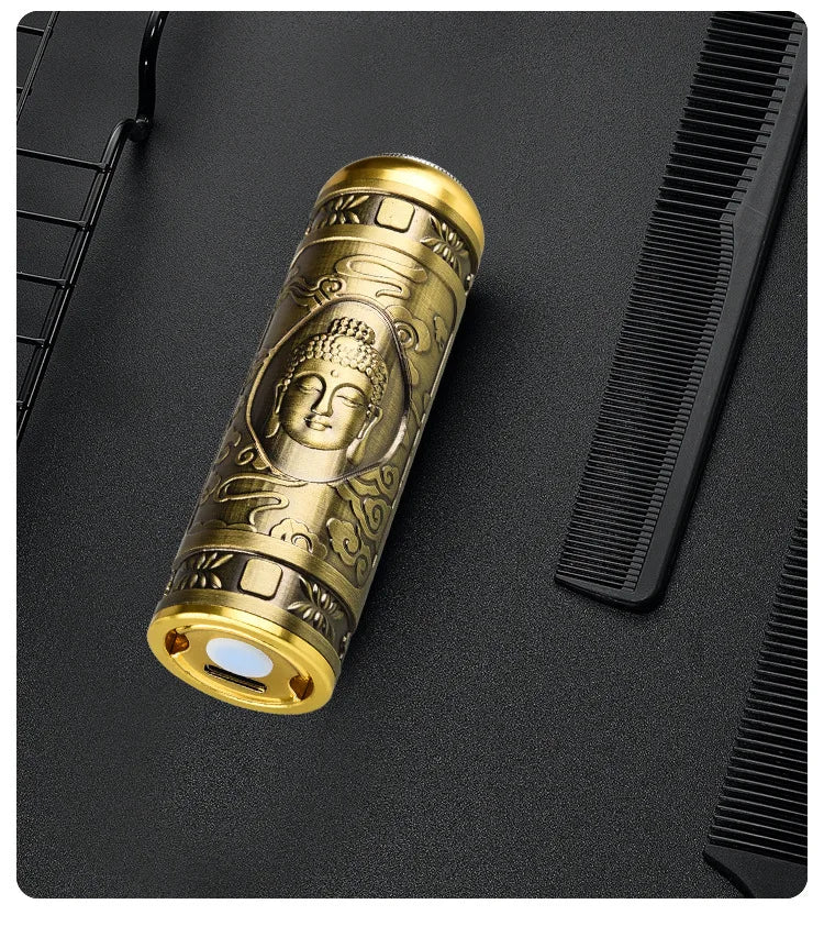 A close-up of a gold-colored electric razor with a Buddha face design resting on a black surface.
