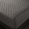 A close-up view of a dark gray quilted waterproof mattress protector with deep pockets.