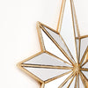 A close-up of an octagonal star resin wall mirror with gold trim and reflective surface.