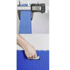A hand is shown using a blue foam kneeling pad with a handle for gardening or yoga.