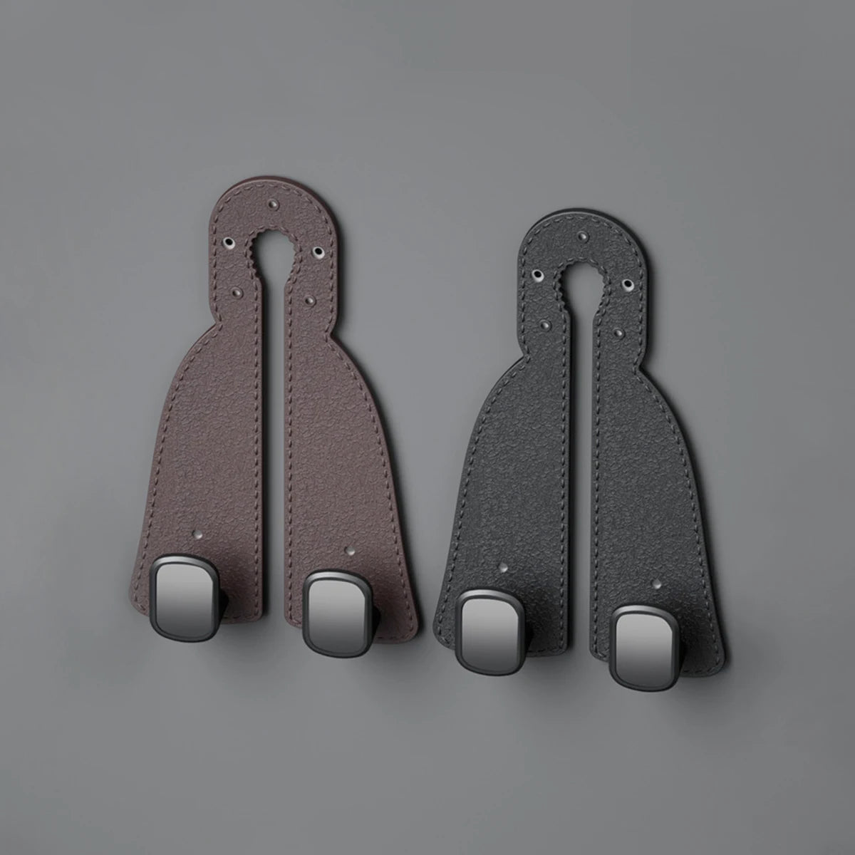 Two dark brown leather headrest hooks designed as a tidy organizer for bags, groceries, and coats