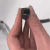A hand holds a black U-shaped rubber edge trim with a metal core for automotive applications.