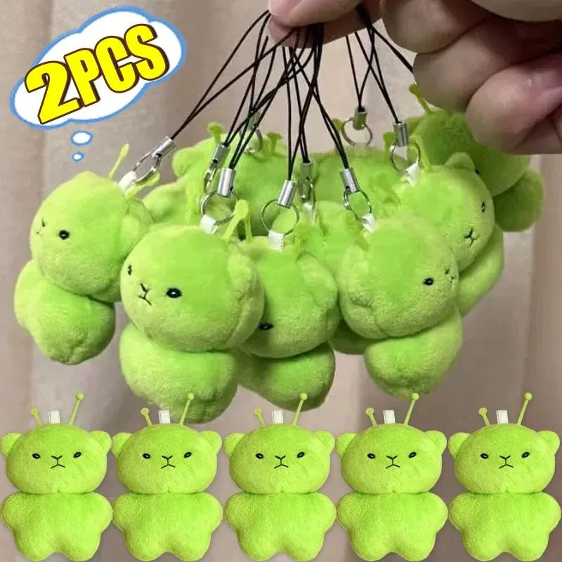 A collection of cute, soft green alien plush keychains with small ears and stems.