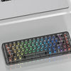A close-up view of a black mechanical keyboard with crystal clear RGB backlit keycaps and a separate keycap shown next to it.