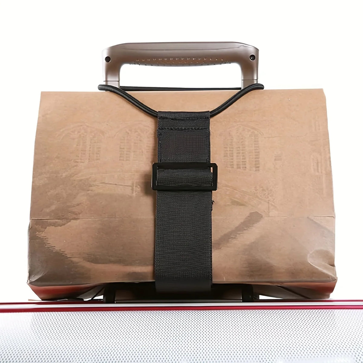 A brown reusable elastic luggage strap with a dark strap and leather handle is shown on a clear surface.