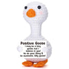 A white crochet goose figurine with an orange beak and a card that says Positive Goose