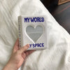 A white mini photo album titled My World with a heart-shaped clear window on the cover