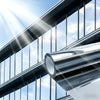 Close-up view of a silver frosted privacy window film installed on a modern glass facade.