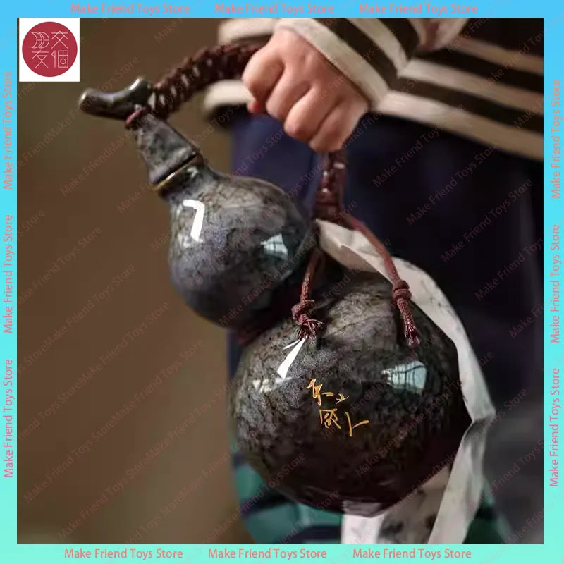 A hand is holding a dark, spherical ceramic gourd with a decorative knot and a white cloth bag.