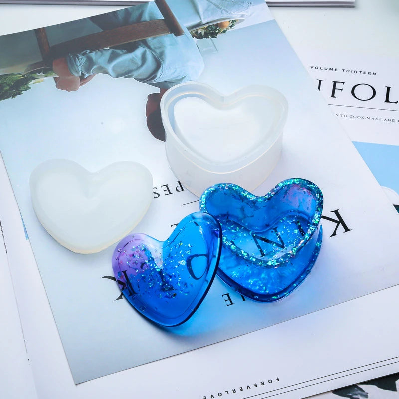 A set of silicone jewelry boxes and molds in white and blue heart shapes displayed on a magazine page.
