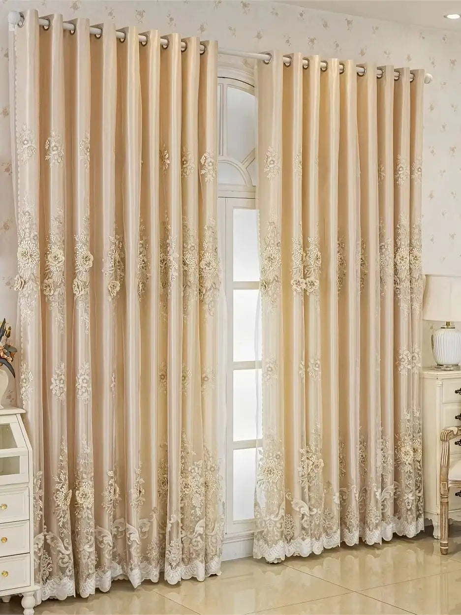 Double layer embroidered beige blackout curtain panels hanging in a light-colored room.