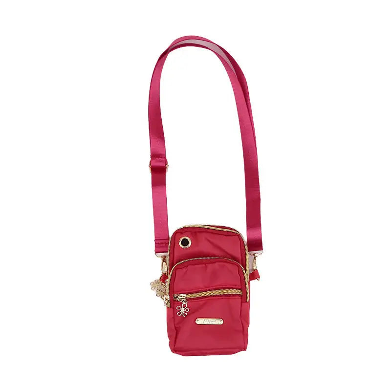 Bolso cruz impermeable de nylon color granate con correa larga.