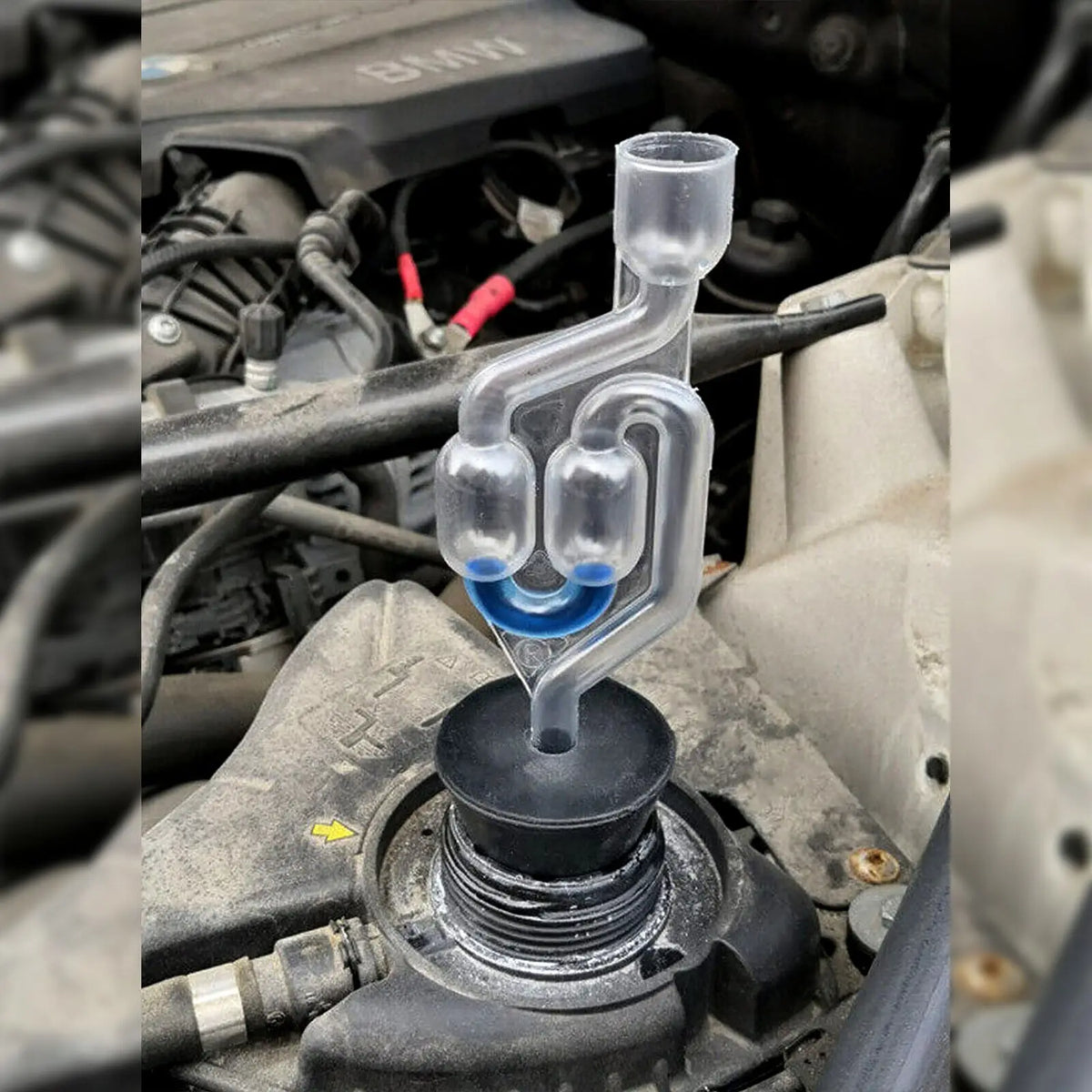 A clear plastic tube with a connector is shown attached to an engine component, likely for combustion leak testing.