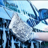 A hand wearing a blizzard high foam car wash mitt is cleaning water streaks off a car's surface.