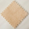 A square patch of light beige soft plush interlocking floor tiles.