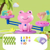 A pink frog balance math learning toy with numbers and counting blocks on a blue rail.