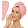 A woman is wearing a pink microfiber hair drying towel wrap on her head.