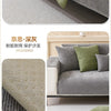 A close-up of a solid gray chenille non-slip sofa cover with a protective layer shown on a modern sofa.
