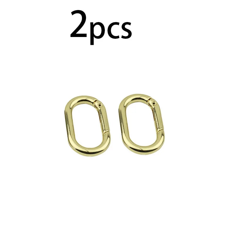 Zwei goldene ovale Feder O-Ring-Schnallen für Taschen und Gürtel