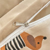 Close-up of a beige duvet cover featuring an orange and black striped dog print with a silver zipper detail.