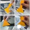A hand is applying a yellow professional car window tint kit to the glass surface of a car window.