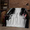 A black and white graphic blanket featuring a stylized face with red lightning effects.