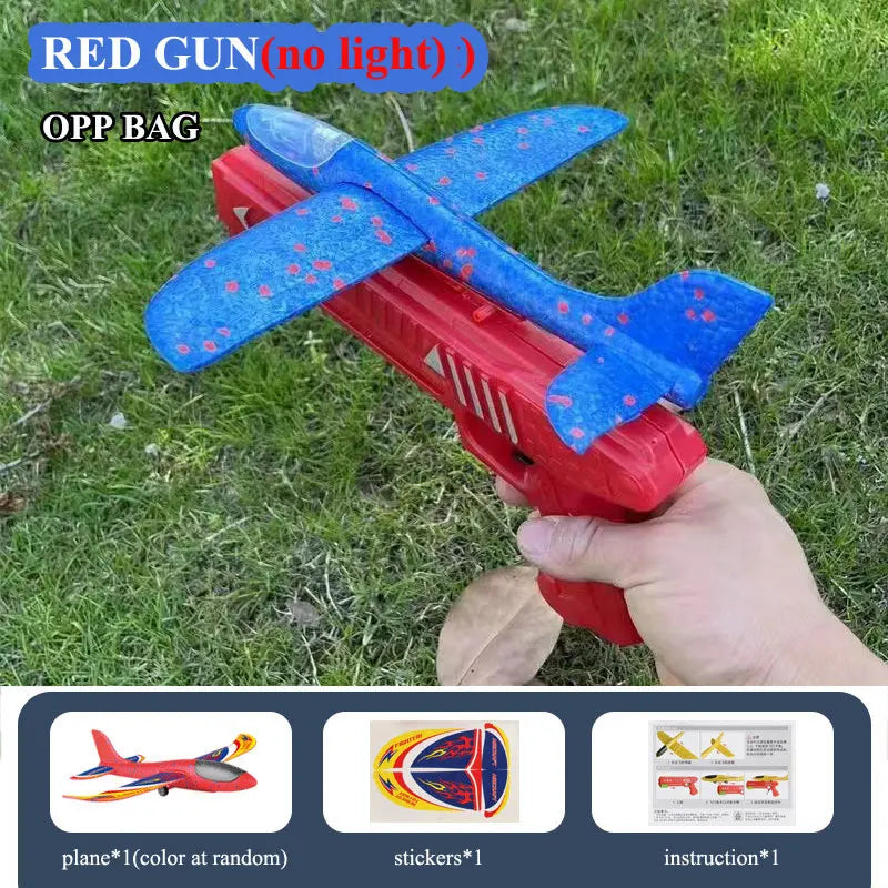 A red foam plane launcher toy with blue accents is shown resting on green grass.