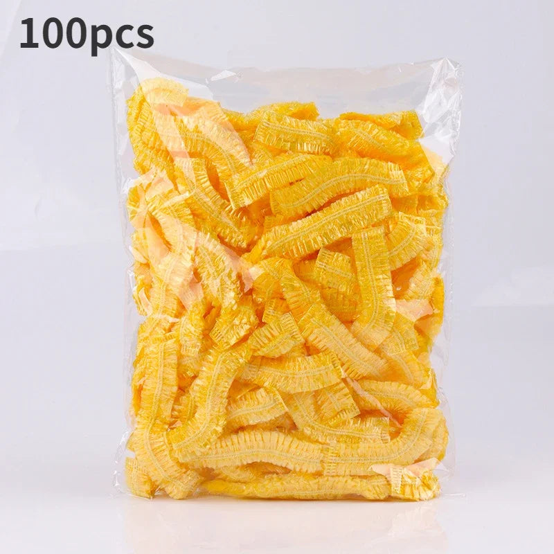 A package containing 100 pieces of yellow disposable transparent waterproof shower caps.