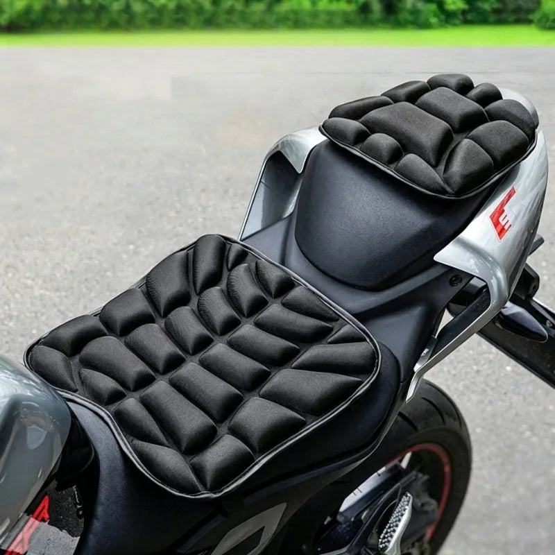 A close-up view of an ergonomic 3D motorcycle seat cushion with black quilted foam padding mounted on a silver motorcycle sea