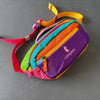 A color block waterproof nylon fanny pack featuring vibrant stripes of pink, red, orange, yellow, and purple.
