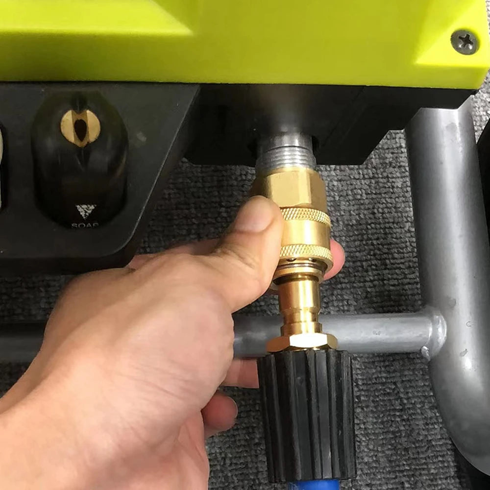 A hand is connecting an M22-15mm to 3/8" quick-connect adapter set for a pressure washer.