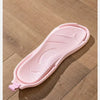 A pink foldable EVA travel slipper with a textured sole is shown on a wooden surface.