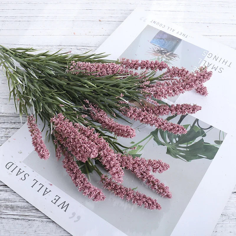 Bündel künstlicher Lavendelblüten auf weißem Papier.